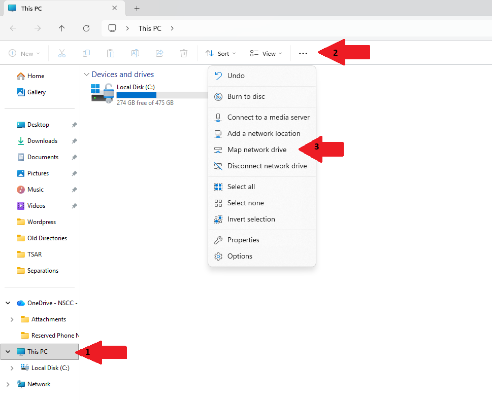 Windows File Explorer window showing “This PC” selected in the left navigation pane. The Devices and drives section displays Local Disk (C:). An overflow menu opened from the toolbar shows options including Burn to disc, Add a network location, and Map network drive, with red arrows pointing to the This PC location, the toolbar menu button, and the Map network drive option.